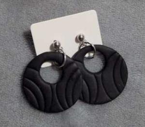 Handmade polymer clay earrings, featuring a round, open-center design with an embossed, wave-like texture.
